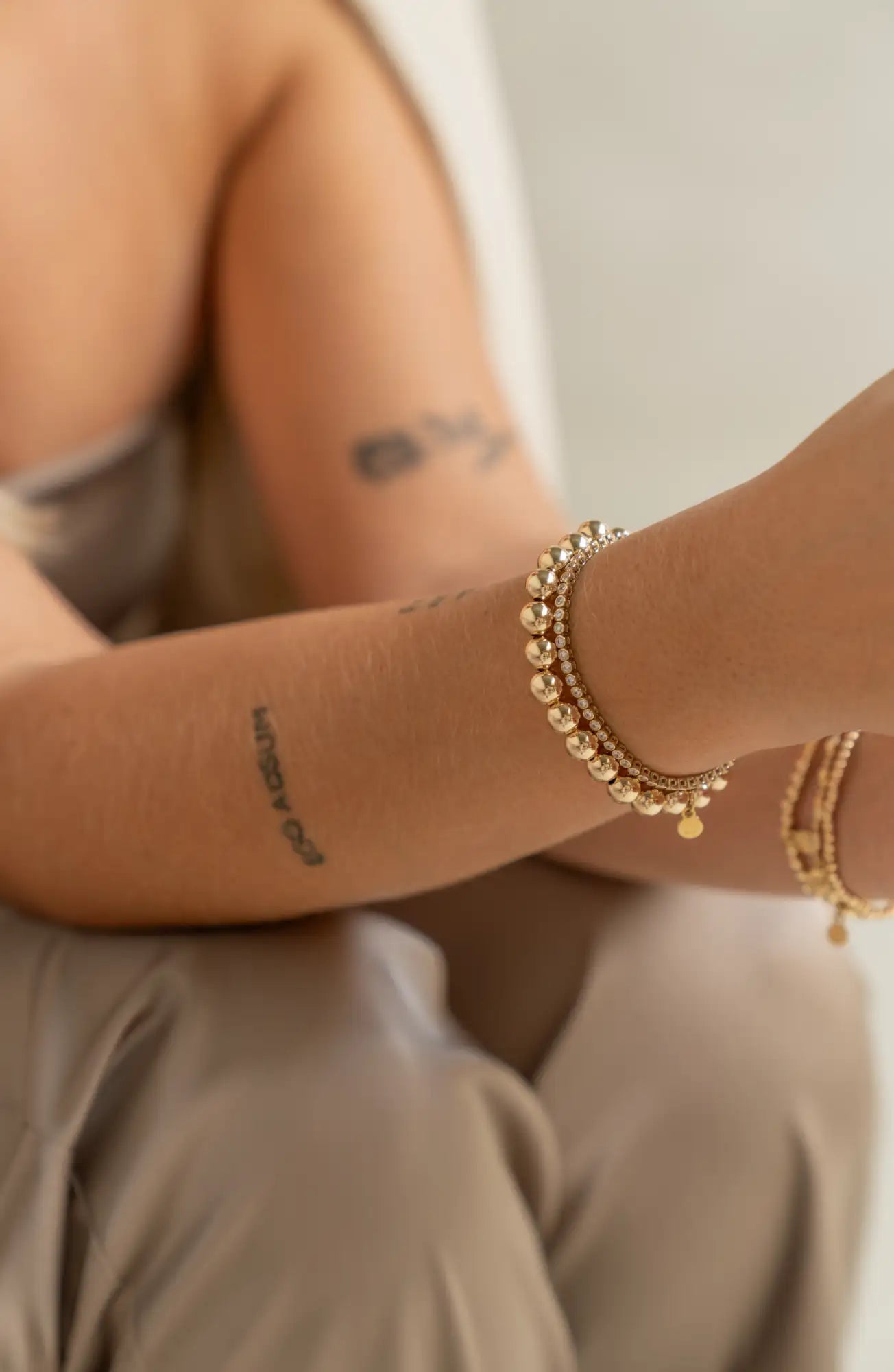 Gouden armband met kralen in goudtint, met kleine bolvormige kraaltjes en een delicaat kettinkjesontwerp.